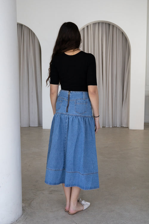Timeless and effortlessly versatile, The Amara Denim Skirt is a modest wardrobe staple designed for everyday comfort and style. Featuring a flattering high-waisted fit, button-front detailing and a softly gathered silhouette, it pairs effortlessly with knitwear, blouses and everyday basics for every season.